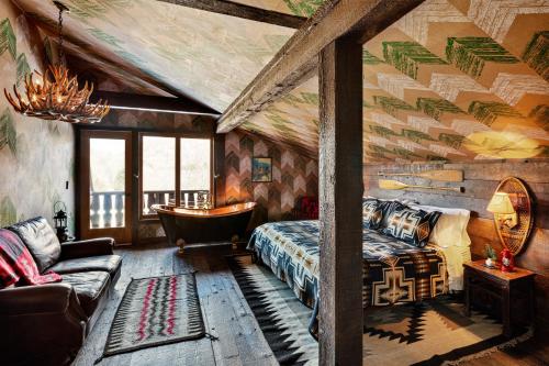 um quarto com uma cama, uma banheira e um sofá em Urban Cowboy Lodge em Big Indian