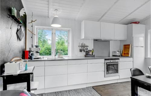 a white kitchen with white cabinets and a window at Cozy Home In Roslev With Wifi in Roslev