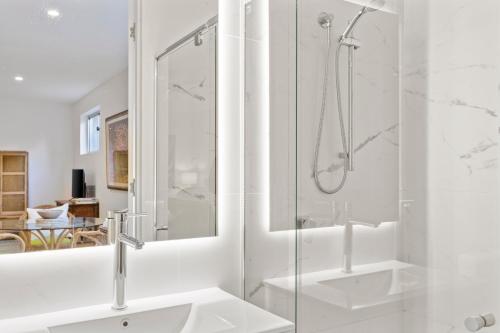 a white bathroom with a shower and a sink at Top of the town in Bangalow