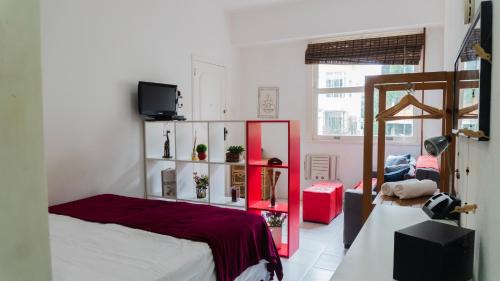 a bedroom with a bed and a red mirror at Studio Copacabana Ipanema in Rio de Janeiro