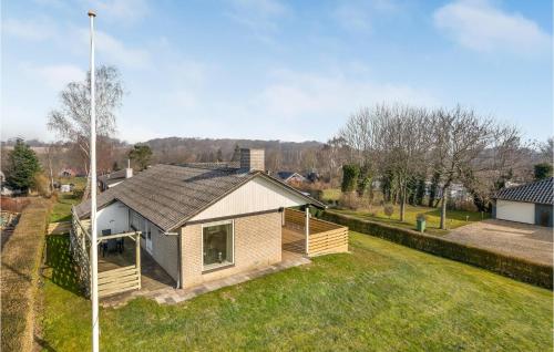 a small house on a field with a yard at 3 Bedroom Cozy Home In Aabenraa in Aabenraa