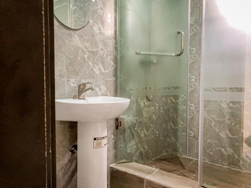 La salle de bains est pourvue d'un lavabo et d'une douche. dans l'établissement ALEXANDRIA COURT, à Lekki