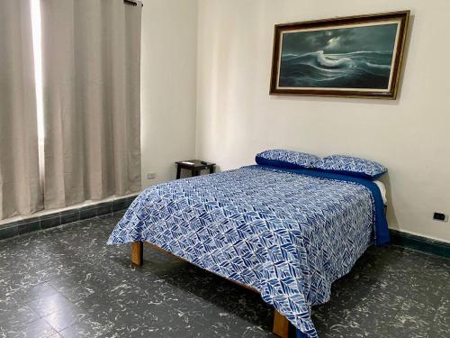 a bedroom with a bed and a painting on the wall at My Family In Monterrey - Hostel in Monterrey
