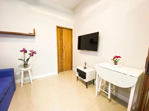 a bathroom with a sink and a tv on a wall at Studio Copacabana Ipanema in Rio de Janeiro