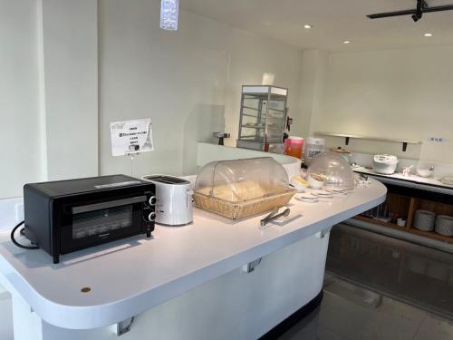 a kitchen with a counter with a microwave on it at Kaishen Sinsu Hotel in Taitung City