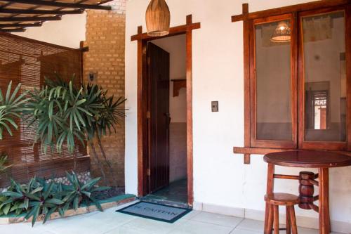an open door of a house with a table and stool at Pousada El Capitan in Barra Grande