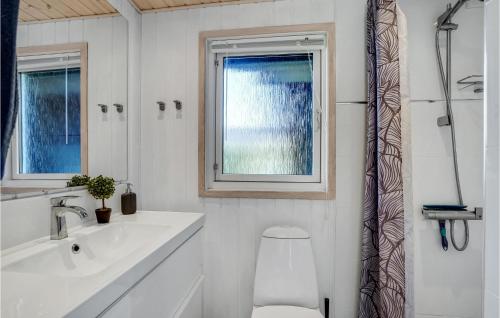 a bathroom with a sink and a toilet and a window at Lovely Home In Lgstr With Kitchen in Løgstør