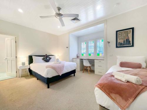a bedroom with two beds and a desk in it at Alfie's Place in Nulkaba