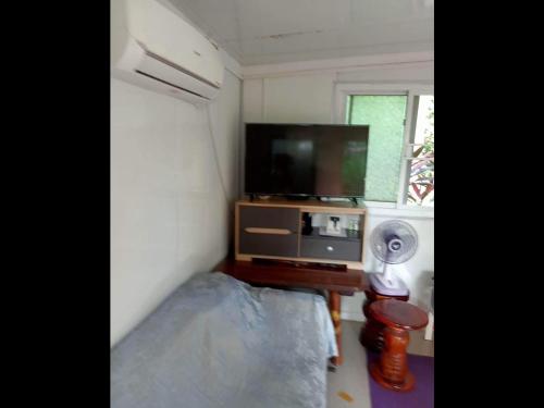 Mały pokój z telewizorem i stołem z wentylatorem w obiekcie บ้านสวนในเมืองปราจีนบุรี 