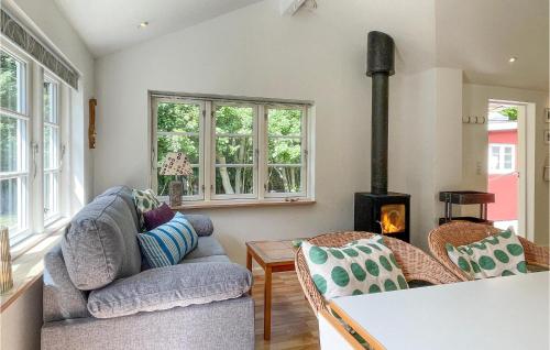 a living room with two chairs and a wood stove at Nice Home In Rnne With Wifi in Rønne