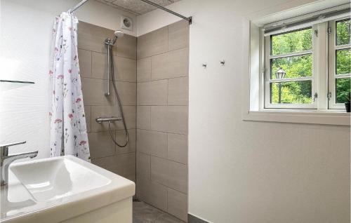 a white bathroom with a sink and a shower at Nice Home In Rnne With Wifi in Rønne