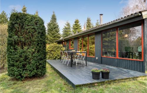a house with a deck with a table and chairs at Awesome Home In Væggerløse With Kitchen in Marielyst