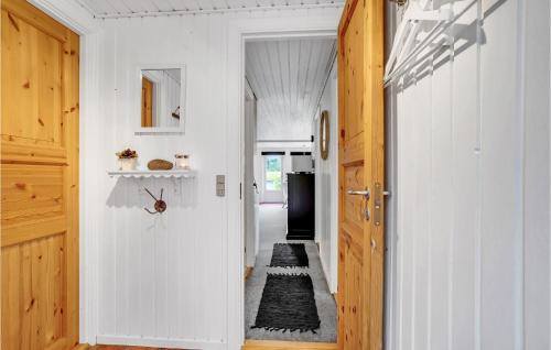 a hallway with a door leading to a kitchen with a refrigerator at Gorgeous Home In Ulfborg With Wifi in Ulfborg