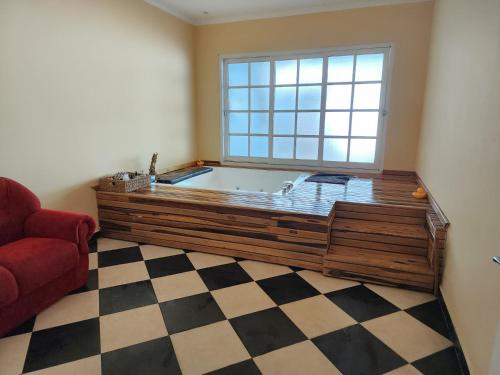 伊瓜蘇港的住宿－El Olimpo，浴缸位于带 ⁇ 格地板的客房
