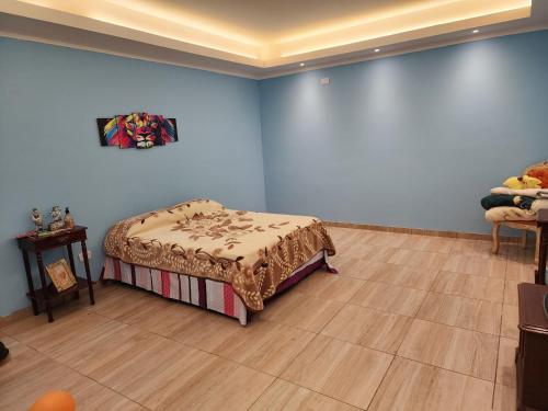 - une chambre avec un lit dans une pièce aux murs bleus dans l'établissement El Olimpo, à Puerto Iguazú