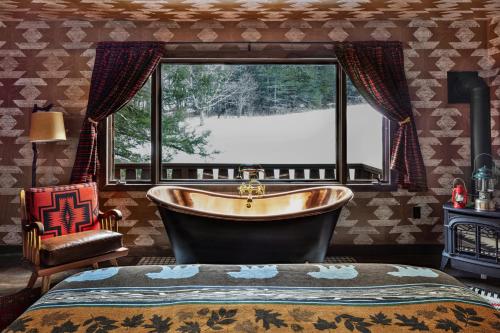 een grote badkamer met een bad en een raam bij Urban Cowboy Lodge in Big Indian
