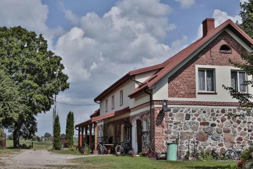 a brick and stone house with a tree at Agropensjonat Stręgielek in Stręgielek