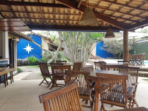 a restaurant with wooden tables and chairs and a blue wall at Pousada El Capitan in Barra Grande