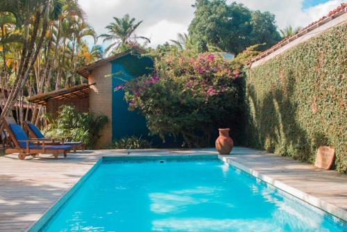 una piscina con un jarrón junto a una pared en Pousada El Capitan, en Barra Grande