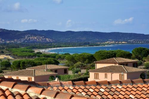 a view of a town with houses and the ocean at Residenze Mare e Pineta in Budoni