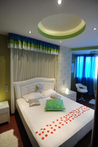 a bedroom with a large white bed with two pillows at Carol Hotel in Piraeus