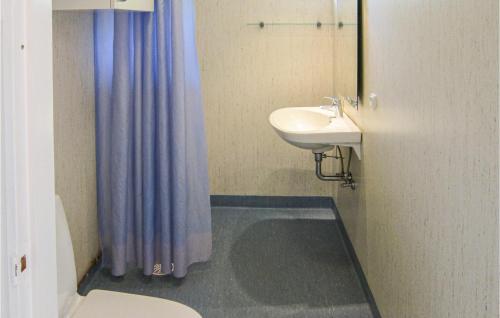 a bathroom with a sink and a toilet and a mirror at Cozy Home In Aakirkeby With Wifi in Vester Sømarken