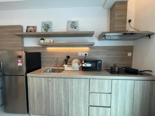 a kitchen with a sink and a refrigerator at 2Bedroom Sutera Avenue Kota Kinabalu by Twen8ty Homestay in Kota Kinabalu