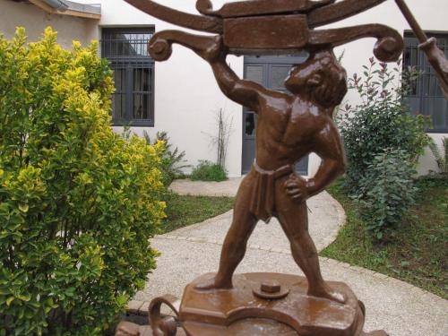 a bronze statue of a boy with a pot at Hôtel Restaurant Spa Le Sauvage in Besançon
