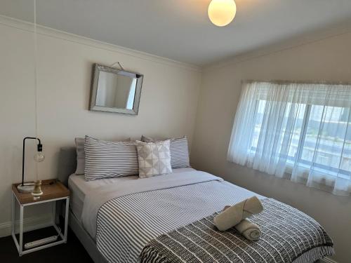 a bedroom with a bed with a hat on it at Cornelias Cottage Mount Gambier Central in Mount Gambier
