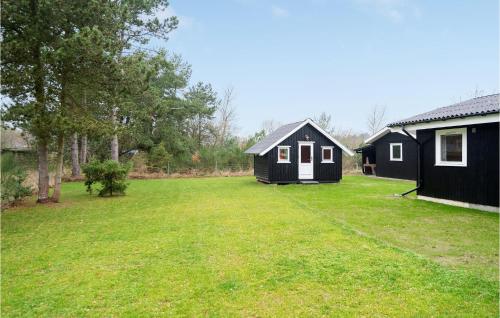 a large yard with two black buildings and a house at Amazing Home In Martofte With Wifi in Martofte