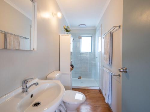 Baño blanco con lavabo y aseo en Blue Wren Cottage Farm Stay, en Yanakie