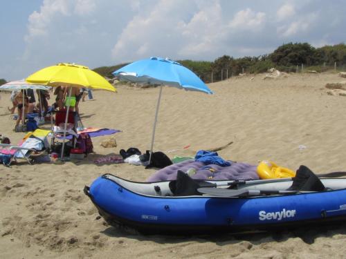a blue kayak and an umbrella on a beach at Casa Solento in Maruggio