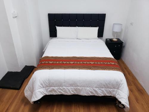 a bedroom with a large bed with a black headboard at Hostal Cusco de mis Sueños in Cusco