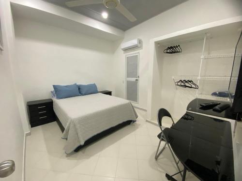 a bedroom with a bed and a desk in it at Hostal La Princesa in Cartagena de Indias