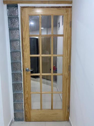 a wooden door with a window in a room at Hostal La Princesa in Cartagena de Indias