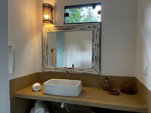 W łazience znajduje się umywalka i lustro. w obiekcie Casa Viva Trancoso w mieście Trancoso