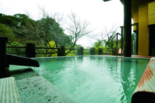 een groot zwembad in een huis met bij Kirishima Momijidani Seiryuso in Kirishima