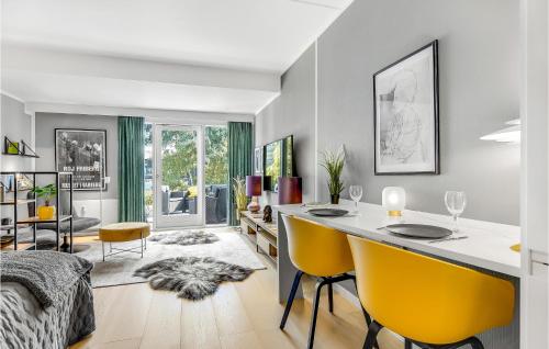 Stunning Home In Helsingr With Wifi في هلسنغور: غرفة معيشة مع طاولة طعام وكراسي صفراء