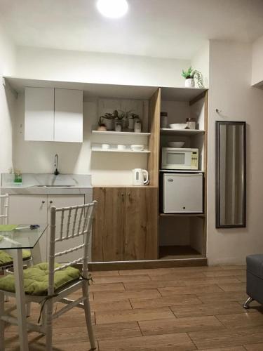 a kitchen with a table and a chair in a room at Los Soles Suite Mall del Sol Guayaquil Airport in Guayaquil