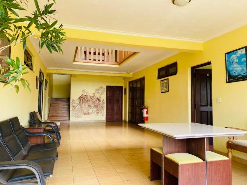 a lobby with yellow walls and a table and chairs at Nature Walk Resort in Kandy