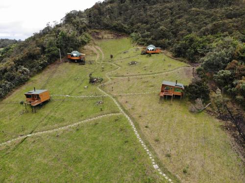 a group of huts on top of a hill at ReverdeSer Glamping in Tabio