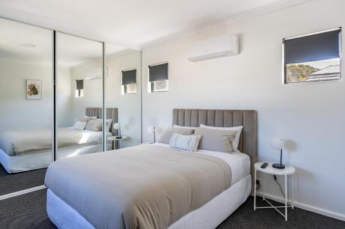 Un dormitorio blanco con una cama grande y espejos. en Town Haus, en Margaret River Town