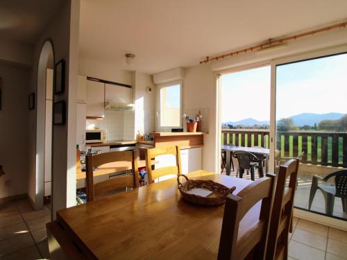une cuisine et une salle à manger avec une table et un balcon dans l'établissement Saint Cyprien : Appartement T3 avec Toit Terrasse, Piscine et Accès Direct à la Plage - FR-1-309-357, à Saint-Cyprien