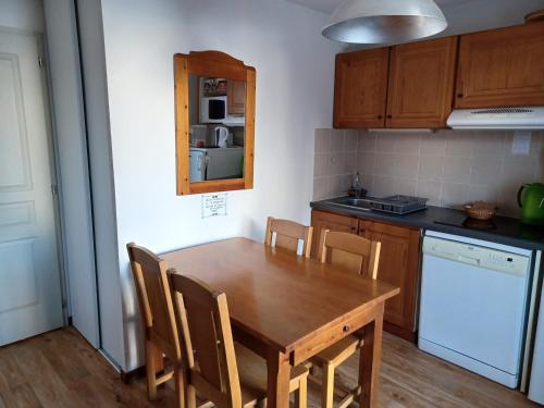 une cuisine avec une table et des chaises en bois dans l'établissement Studio confortable à 300m des pistes avec terrasse et parking - FR-1-618-25, à Albiez-Montrond