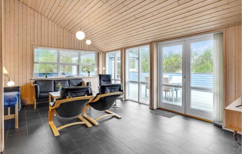 a room with a desk and chairs and windows at Amazing Home In lbk With Sauna in Ålbæk