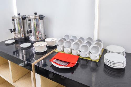 a table with a bunch of cups and plates on it at Hotel Citradream Bandung in Bandung