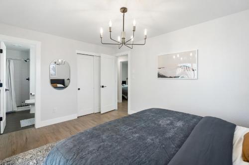 um quarto branco com uma cama e um lustre em @ Marbella - Spacious and Modern Home in Arvada em Arvada