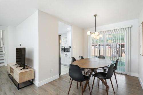 a dining room with a table and chairs and a tv at @ Marbella - Spacious and Modern Home in Arvada in Arvada