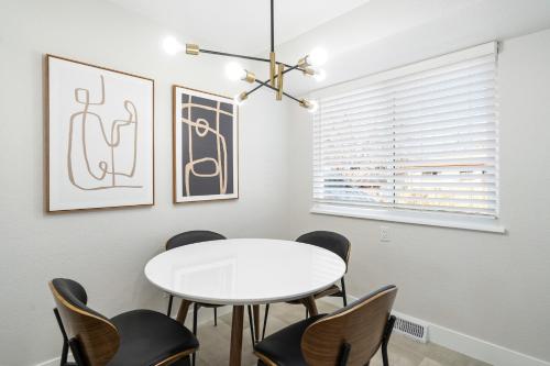 a dining room with a white table and chairs at @ Marbella - Spacious and Modern Home in Arvada in Arvada