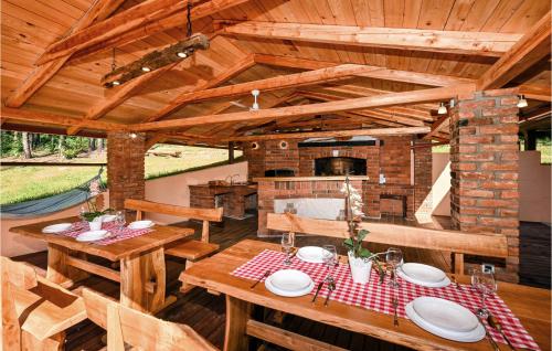 an outdoor dining area with wooden tables and a fireplace at Beautiful Home In Klenovnik With Sauna in Klenovnik